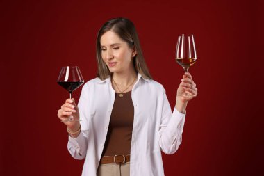 Kırmızı arka planda şarap kadehleri olan profesyonel şarap garsonu.