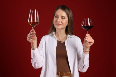 Kırmızı arka planda şarap kadehleri olan profesyonel şarap garsonu.