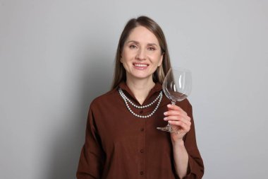 Açık gri arka planda cam camlı profesyonel şarap garsonu.