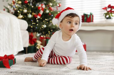 Noel Baba şapkalı küçük çocuk Noel için dekore edilmiş odada.