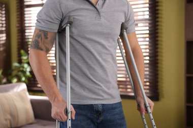 Evde koltuk değneği kullanan bir adam, yakın plan.