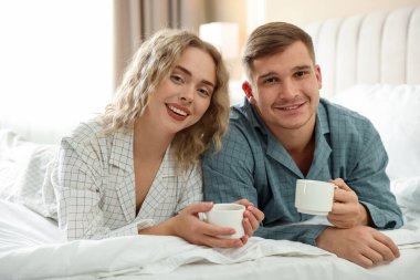 Hoş bir çift evde sıcak içeceklerin tadını çıkarıyor.