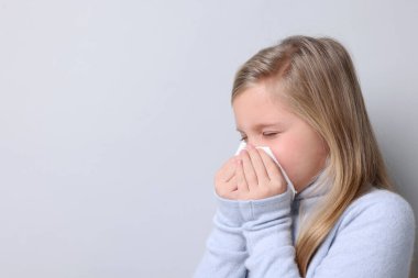 Hafif arka planda burnu akan küçük bir kız, mesaj için yer var. Soğuk Semptom