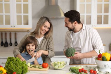 Mutfakta birlikte yemek pişiren mutlu bir aile.