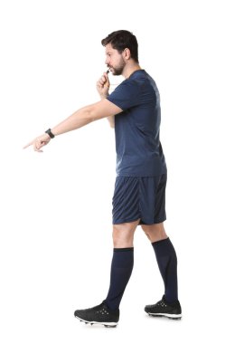 Üniformalı hakem beyaz arka planda düdük çalıyor.