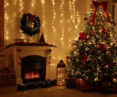 Güzel bir şömine, Noel ağacı ve karanlık odada şenlikli bir dekor. İç tasarım