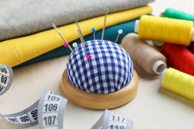 İğneler, iğneler, iplikler, kumaşlar ve mezura desenli iğne desenli iğne deseni, yakın plan.