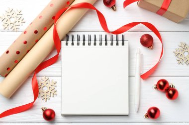 Yeni yıl hedefleri. Boş planlayıcı, kalem ve beyaz ahşap masa üzerinde şenlikli bir dekor.