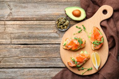 Ahşap masada servis edilen havyar, somon, avokado ve mikroyeşillikli nefis bruschetalar. Metin için boşluk