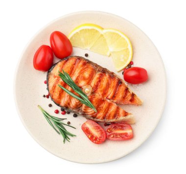 Lezzetli ızgara somon bifteği, domates, limon ve biberiye beyaza izole edilmiş.