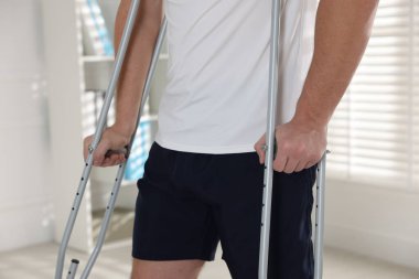 Evde koltuk değneği kullanan bir adam, yakın plan.