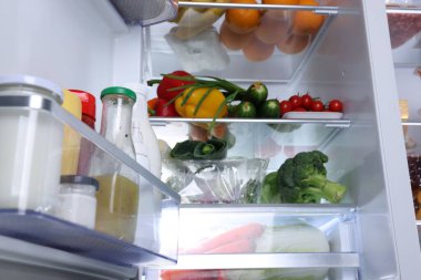 Farklı taze gıda ürünleri ve düşük açılı manzaralı modern buzdolabı.