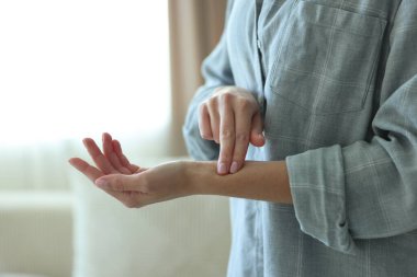 Kadın nabzını içeride kontrol ediyor, yakın plan.