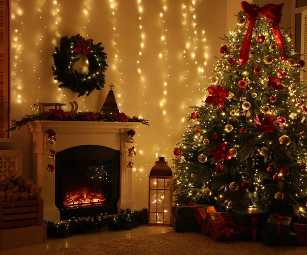 Güzel bir şömine, Noel ağacı ve karanlık odada şenlikli bir dekor. İç tasarım