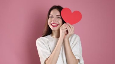 Sevgililer Günü. Pembe arka planda kağıt kalpli bir kadın.