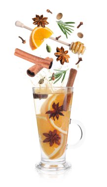 Sıcak şarap tarifi. Baharatlar ve diğer malzemeler cam bardağa dökülüyor ve beyaz arka planda içecek var.