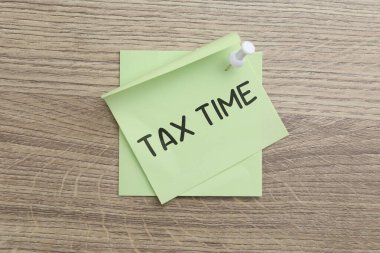 Tahta zemin üzerinde metin Vergi Saati olan kağıt not, üst görünüm