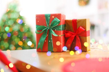 Hediye kutuları masanın üzerinde, ışıkları bokeh. Mutlu Noeller ve mutlu yıllar.