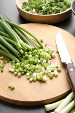 Gri masada yeşil soğan ve bıçak, yakın plan.