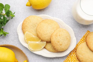 Lezzetli limonlu kurabiyeler, nane, süt ve meyveler ışık masasında.