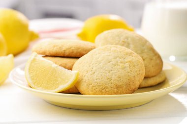 Lezzetli limonlu kurabiyeler ve beyaz ahşap masada meyveler, yakın plan.