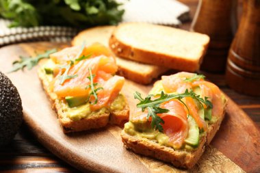 Somon, roka ve avokado ile nefis bruschetalar ahşap masada, yakın plan.