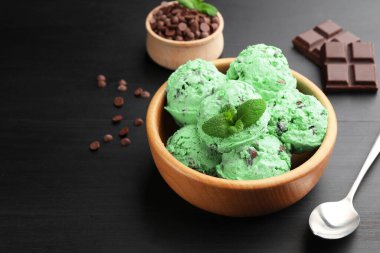 Siyah ahşap masada servis edilen naneli çikolatalı dondurma. Metin için boşluk