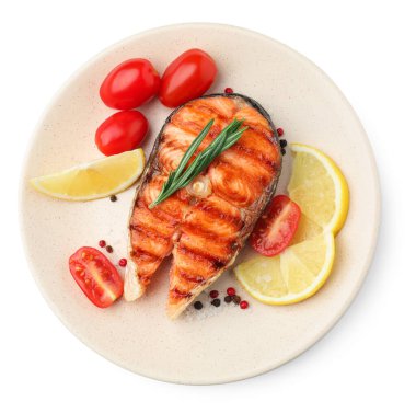 Lezzetli ızgara somon bifteği, domates, limon ve biberiye beyaza izole edilmiş.