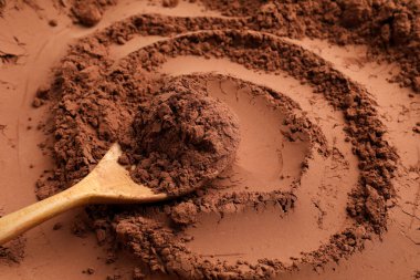 Arkaplan olarak kakao tozu ve tahta kaşık, yakın plan.