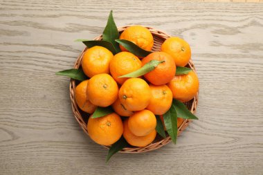Taze mandalina ve yeşil yapraklar ahşap masa, üst manzara