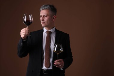 Kahverengi arka planda şarap kadehleri olan profesyonel şarap garsonu.