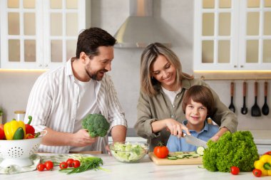 Mutfakta birlikte yemek pişiren mutlu bir aile.