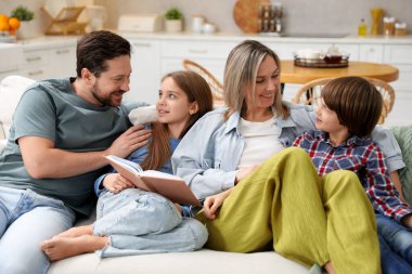 Mutlu aile kitapları okumak ve evdeki mutfakta kanepede birlikte vakit geçirmek.