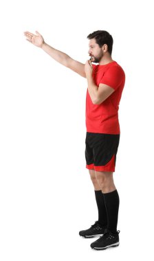 Üniformalı hakem beyaz arka planda düdük çalıyor.