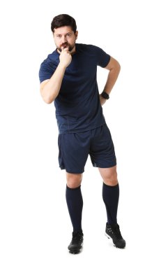 Üniformalı hakem beyaz arka planda düdük çalıyor.