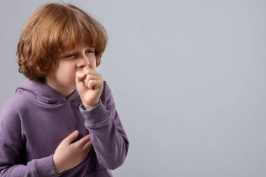 Küçük çocuk arka planda öksürüyor, mesaj için yer var. Soğuk Semptom