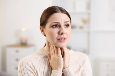 Evde boğaz ağrısı çeken bir kadın. Soğuk Semptom