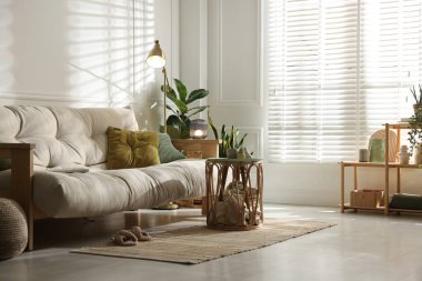 Kanepesi ve çiçekleri olan şık bir oturma odası. İç tasarım