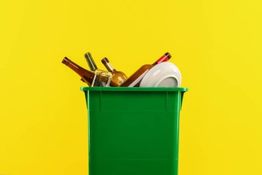 Çöp tenekesi turuncu arka planda, yakın plan. Atık sıralama