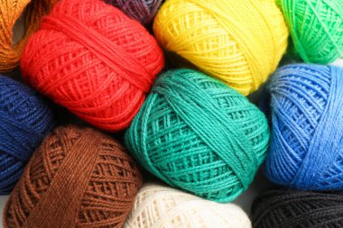 Farklı ipliklerden oluşan toplar arka plan olarak, yakın plan