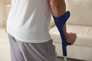 Dirsek değnekli adam evde, yakın plan.