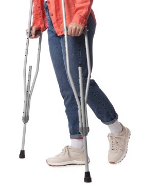 Beyaz arka planda koltuk değnekli kadın, yakın plan.