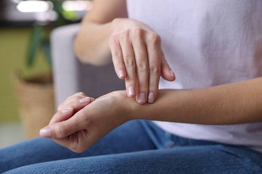 Kadın nabzını evde kontrol ediyor, yakın plan.