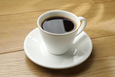 Ahşap masada, fincanda Aromatik kahve, yakın plan.