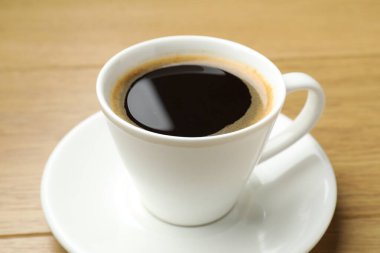 Ahşap masada, fincanda Aromatik kahve, yakın plan.