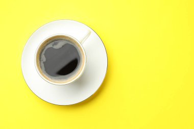 Sarı masada fincanda Aromatik kahve, üst manzara. Metin için boşluk