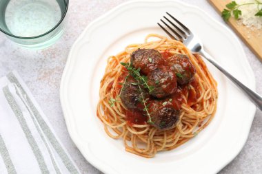 Açık gri masada servis edilen köfteli leziz makarna.