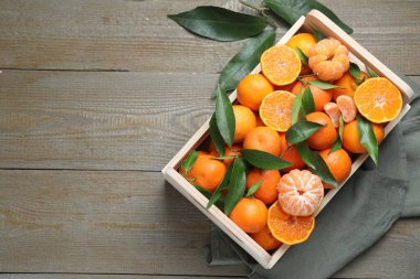 Taze mandalina ve yeşil yapraklar ahşap masa üzerinde, üst manzara. Metin için boşluk