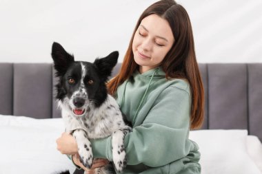 Evde yatağında Collie köpeği olan bir kadın.