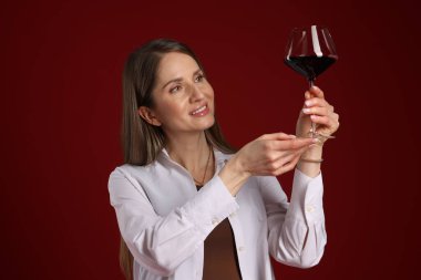 Kırmızı arka planda şarap kadehi olan profesyonel şarap garsonu.